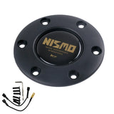 A black NISMO vintage horn button with a gold logo, alongside a horn cover and installation hardware.
