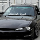 Black car with 'misunderstood' decal on windshield in a garage setting