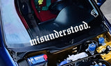Car hood with 'misunderstood' decal and engine components visible