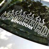 Decal with 'LOWIRED KINGDOM' on a car window with tree reflection
