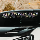 Car with 'Bad Drivers Club' decal on a blurred natural background