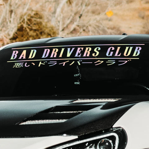 Car with 'Bad Drivers Club' decal on a blurred natural background