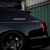 Black car with 'misunderstood' decal on a dark background