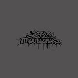 Graffiti-style text 'Troublemaker' on a gray background
