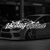 Car with 'Locally Hated' decal in a dark setting