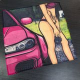 Pink car with a person in a bikini sitting on it, on a dark textured surface