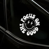 White decal with 'Focus on the Good' text on a black car window