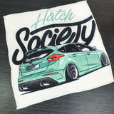 Tea towel with a green hatchback car design and 'Hatch Society' text on a white background.