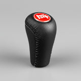 Black leather gear shift knob with red and white logo on a black background