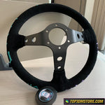 Black steering wheel on a wooden surface with a blurred background