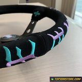 Black steering wheel cover with colorful embroidery on a table, brand 'TopJDMStore.com' visible.