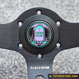Close-up of a black metal object with a circular design and 'Pablo Edition' text on a gray background.