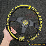 Steering wheel with 'Mooneyes' branding held by a hand on a textured background