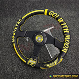 Black and yellow steering wheel with text on a textured gray background