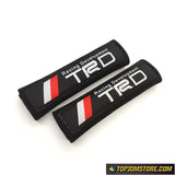 TRD cotton seat belt pads in black with white "Racing Development" embroidery.
